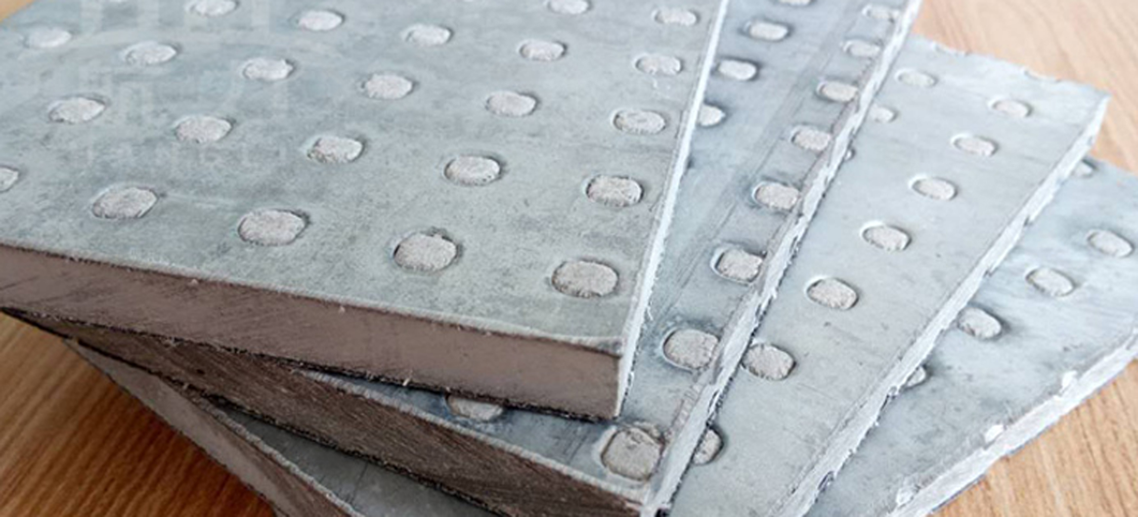 纖維水泥抗爆板又稱防爆板是為存在潛在爆炸危險區(qū)域、防震等特殊工作系統(tǒng)要求提供解決方案而研發(fā)生產(chǎn)的一種特殊板材，它是由增強纖維水泥板表面加壓鍍鋅鋼材料所構(gòu)成，具有良好的抗爆及阻燃效果。由于板材內(nèi)部特殊的構(gòu)造可以有效減輕爆炸的沖擊，耐久性高，九德增強纖維水泥抗爆板依據(jù)專門爆破檢測機構(gòu)的嚴格檢測，單板抗爆能力高達1.6MPa，抗爆墻抗爆能力高達2.0MPa，遠高于國家相關(guān)標準規(guī)定的墻體抗爆1.4Mpa。